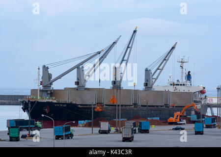 Uniplus bulk carrier Kränen entladen Lasten mit Kipper Warten auf Laden, Hualien Port, Hualien City, Taiwan Stockfoto