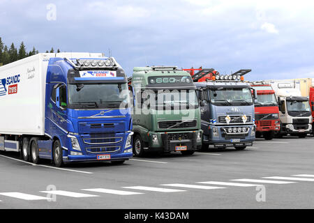 Mariehamn, Finnland - 25. AUGUST 2017: Bunte Volvo Trucks auf dem Asphalt Hof von einem Truck Stop an einem bewölkten Tag geparkt. Stockfoto