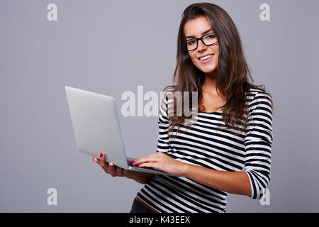 Studio erschossen Der junge Brünette mit Laptop Stockfoto