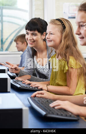 Weibliche Grundschule Schüler im Informatikunterricht mit Lehrer Stockfoto