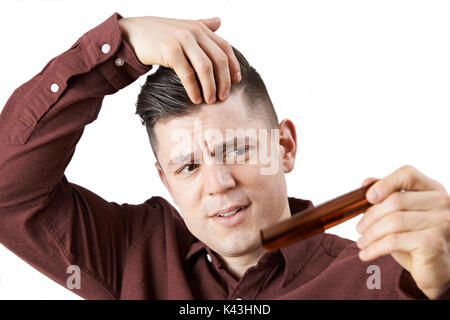 Mann mit Kamm besorgt über Haarausfall Stockfoto