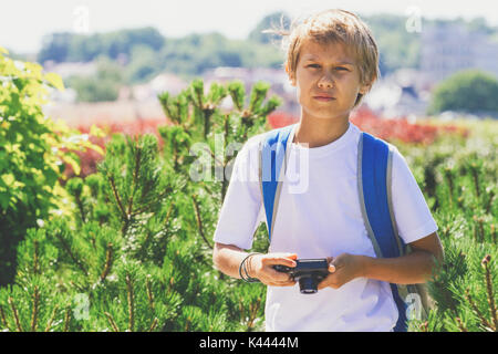 Kleiner Junge mit einer Digitalkamera fotografieren im freien Stockfoto