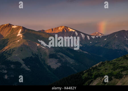 Ein kleiner Regenbogen macht ein Aussehen während der Sonnenaufgang von Vasquez Peak in Colorado. Stockfoto