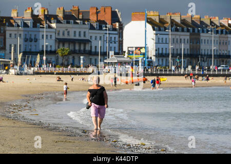 Dorchester, Dorset, Großbritannien. 4. September 2017. UK Wetter. Am späten Nachmittag die Sonne bricht durch die Wolken an einem warmen Tag als Besucher am ruhigen Strand in den Badeort Weymouth in Dorset genießen. Photo Credit: Graham Jagd-/Alamy leben Nachrichten Stockfoto