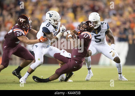 Landover, Maryland, USA. 3. Sep 2017. Virginia Tech Hokies Quarterback Josh JACKSON (17) Hält auf die Kugel, West Virginia Bergsteiger Sicherheit KYZIR WEISS (8) war erfolglos, versucht, es während des Spiels zu Streifen bei FedEx Field in Landover, Md gespielt. Virginia Tech beat WVU 31-24. Credit: Ken Inness/ZUMA Draht/Alamy leben Nachrichten Stockfoto