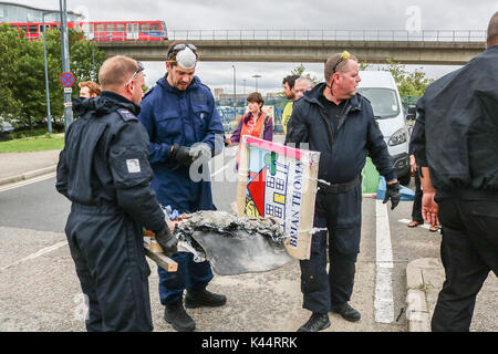 London, Großbritannien. 5. Sep 2017. Entfernen Sie die Polizei street sign, die eine demonstrantin als Frieden mitkämpfer von Quaker und interreligiöse Gruppen und Anti-kriegs-Aktivisten befestigt war außerhalb der Excel Centre in East London sammeln gegen den Waffenhandel zu protestieren vor dem Start der DSEI arme Fair Credit: Amer ghazzal/Alamy leben Nachrichten Stockfoto