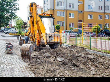 Bau einer neuen Straße. Bagger bereitet die Oberfläche in der Stadt im Sommer Tag Stockfoto