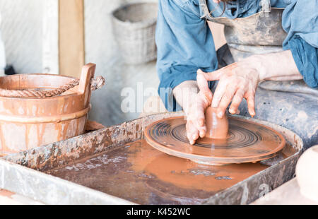 Mann, der Topf auf Töpferscheibe in einem Workshop Stockfoto