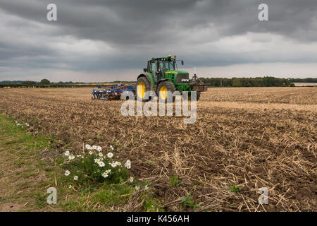 Großbritannien Landwirtschaft - 4 meter Philip Watkins Falten gezogenen drücken und John Deere 7530 Traktor bei der Arbeit die Kultivierung eines Feldes von Weizen zur Kontrolle der Schnitthöhe Stockfoto