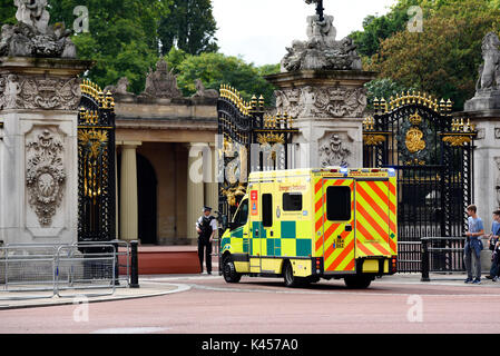 NHS-Krankenwagen kommt am Buckingham Palace Gate, London, Großbritannien, mit bewaffneter Sicherheitspolizei. Stockfoto