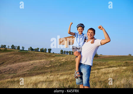 Vater und Sohn zeigen Muskeln in der Natur. Stockfoto
