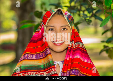 QUITO, ECUADOR - August, 30 2017: Nicht identifizierte Junge indigene Frau trägt einen typisch andinen Kleidung, die ihren Kopf mit einem bunten Decke im Park Stockfoto