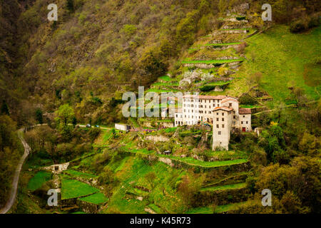 Dorf Bauernhäuser, Contrada Giaconi, Val Frenzela, Valstagna, Provinz Verona, Venetien, Italien. Gebäude aus Stein auf terrassenförmig angelegten Grundstück. Stockfoto