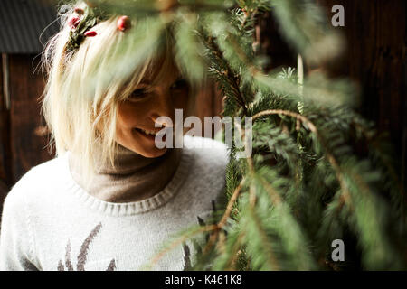 Blonde Frau, Kopfschmuck, Girlande mit Hagebutten, Zweige von Evergreens für Dekoration, Porträt Stockfoto