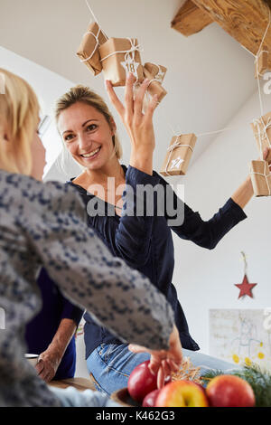 Großmutter, Mutter und Tochter Auflegen einen Adventskalender, Stockfoto