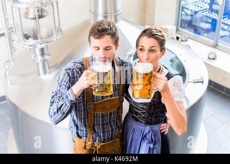 Brauer und Frau Toasten in Bierbrauerei Stockfoto