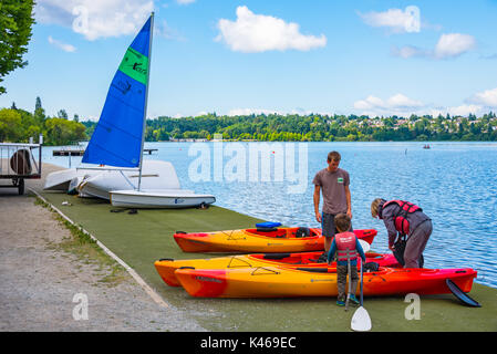 Großmutter und Enkel Schwimmwesten und Vorbereitung in Kayak in Green Lake City Park, Seattle, Washington zu erhalten Stockfoto