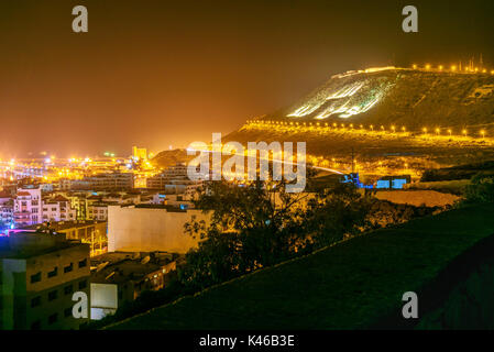 Anzeigen Hill am Strand in Agadir City bei Nacht, Marokko. Der Berg trägt die Inschrift in Arabisch: Gott, Vaterland, König Stockfoto