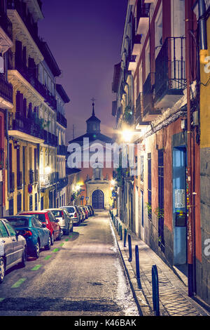 Enge Strasse mit Kirche San Lorenzo im Hintergrund bei Lavapies Nachbarschaft. Madrid. Spanien Stockfoto