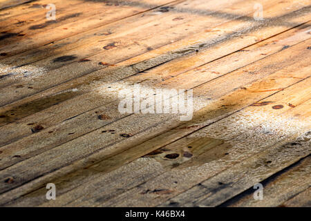 Wet Deck boards Oberfläche mit Regentropfen. regen Wassertropfen glänzend in der Sonne. Stockfoto