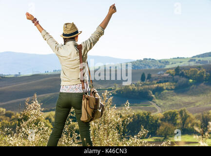 Entdecken Sie magische Ausblicke auf die Toskana. Von hinten aktive Frau Wanderer in hat Wandern in der Toskana gesehen Freude Stockfoto