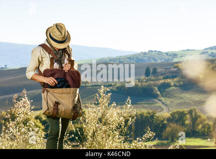 Entdecken Sie magische Ausblicke der Toskana. junge Frau Wanderer mit Tasche wandern in der Toskana die Ferngläser Stockfoto