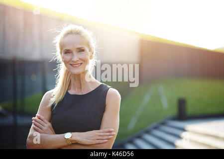 Close up Portrait von Happy Geschäftsfrau, draußen Stehen mit verschränkten Armen. Stockfoto