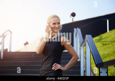 Portrait von zuversichtlich reife Geschäftsfrau im Gespräch auf das Handy. Stockfoto