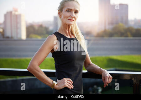 Portrait von zuversichtlich reife Geschäftsfrau mit Blick auf die Stadt im Hintergrund. Stockfoto