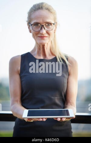 Gesicht portrait von Reifen zuversichtlich Geschäftsfrau holding Tablet. Stockfoto