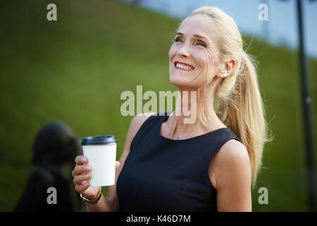 Close up Portrait von schöne, reife Frau lachend Holding Kaffeetasse. Stockfoto