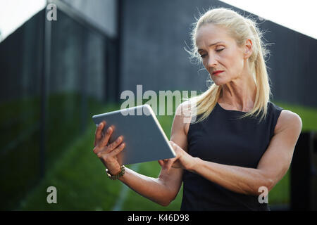 Close up Portrait der Unternehmerin Kontrolle Informationen über Tablet. Stockfoto