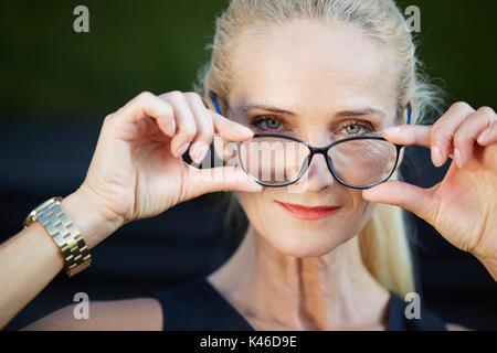 Close up Portrait von froh Geschäftsfrau holding Schauspiele. Stockfoto