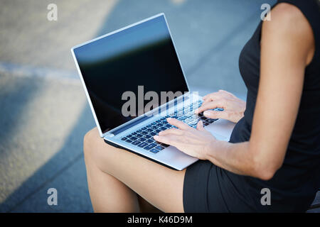 Close up Portrait von unkenntlich Frau Arbeiten am Laptop draußen sitzen. Stockfoto