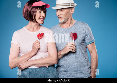 Modische ältere Paare und lächelnd Lutscher isoliert auf Blau Stockfoto