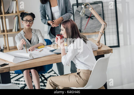 Multiethnische Gruppe von Professionellen junge Architekten arbeiten mit Plänen in modernen Büro Stockfoto