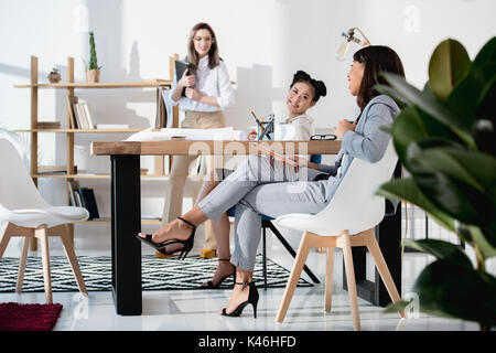 Jungen multiethnischen Geschäftsfrauen in formalen tragen zusammen an die Arbeit im Büro Stockfoto
