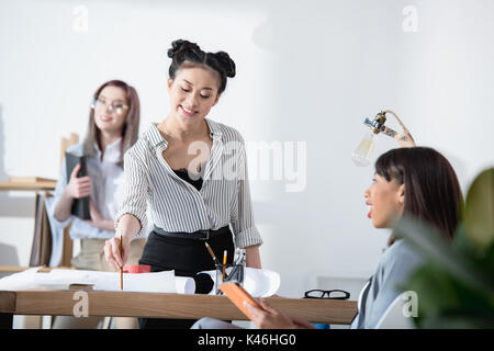 Jungen multiethnischen Geschäftsfrauen in formalen tragen zusammen an die Arbeit im Büro Stockfoto