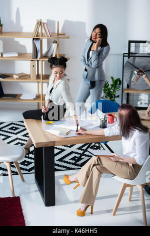 Jungen multiethnischen Geschäftsfrauen in formalen tragen zusammen an die Arbeit im Büro Stockfoto
