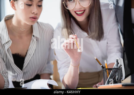 Jungen multiethnischen Designer in formale Abnutzung, Schreibarbeiten im Büro Stockfoto