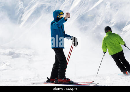 Skifahrer macht selfie auf Kamerahandy und Schnee Berge im Nebel im Hintergrund. Kaukasus Berge im Winter, Georgien, Region Gudauri. Stockfoto