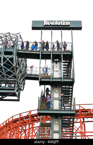 Die Menschen in der Warteschlange für die Revolution Achterbahnfahrt auf Blackpool Pleasure Beach Amusement Park Stockfoto