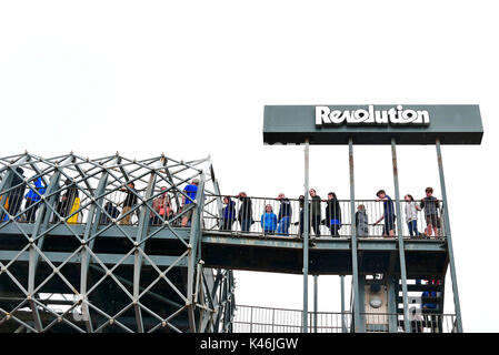 Die Menschen in der Warteschlange für die Revolution Achterbahnfahrt auf Blackpool Pleasure Beach Amusement Park Stockfoto