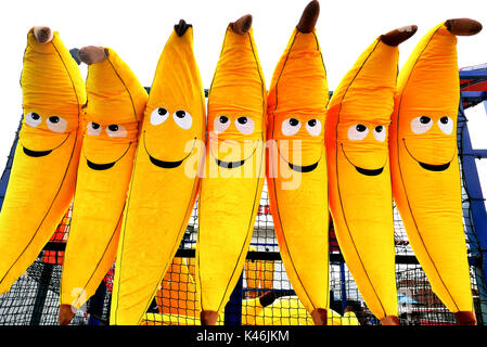 Riesige aufblasbare Spielzeugbananen mit Smiley-Gesichtern auf einem Spielzeugstand gewinnen, Blackpool Pleasure Beach Stockfoto