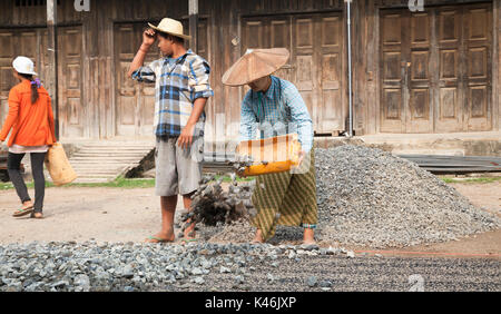 Weibliche Bauarbeiter Instandsetzung der Straße mit Aggregat, Hsipaw, Myanmar Stockfoto