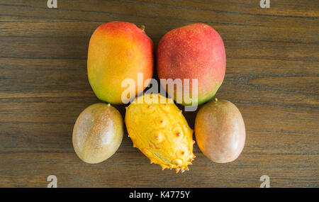 Mango, Passionsfrucht, Melone isoliert auf einem holztisch von oben gesehen Stockfoto