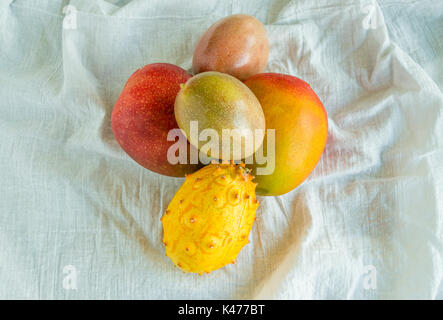 Mango, Passionsfrucht, Melone auf einem weißen Tuch gesehen von oben Stockfoto