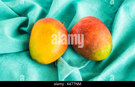 2 Mangos isoliert auf ein grünes Tuch von oben gesehen Stockfoto