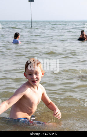 Ein achtjähriger Junge spielt im Meer in Southend-on-Sea, Essex, Großbritannien Stockfoto