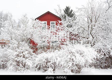Schönen ländlichen Winterlandschaft mit Holz- Haus und Bäume im Schnee. winterlich frostigen Tag Stockfoto
